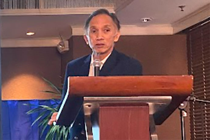 Eduardo V. Francisco standing behind the podium